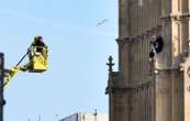 Avec un drapeau palestinien et un keffieh, un homme escalade Big Ben