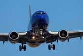 A Southwest passenger kicked and spat at the crew when they tried to stop her from opening an exit in midair, affidavit says