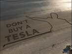 Activists used a Tesla to write 'Don't buy a Tesla' on a beach in Wales