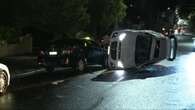 Car flips after crashing into two parked vehicles, sparking manhunt