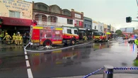 Fire erupts as car ploughs into shopfront on busy Sydney street