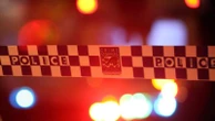 Man armed with axe accused of holding three people hostage in NSW home