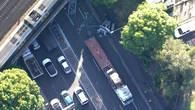 Crane crashes into rail bridge causing peak-hour delays in Sydney