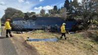Driver trapped for two hours as truck carrying horse float flips on busy highway