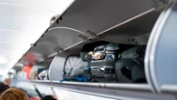Por qué las aerolíneas quieren cerrar con llave el compartimento superior para maletas de los aviones