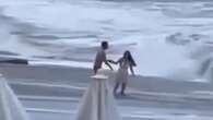 Angustioso momento: una mujer es engullida por el mar tras un romántico beso con su novio en la playa