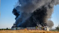 Un incendio en una fábrica provoca una gran columna de humo negro y obliga a evacuar a los vecinos en Burguillos, Sevilla