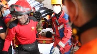 Children found alive beneath rubble of collapsed Indonesian school