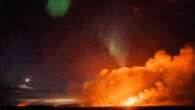 Northern lights dance above erupting volcano