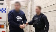 Rebels bikie charged over video of caged cat being shot at point blank