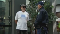 Man wearing swastika shirt outside royal commission hearing moved on by police