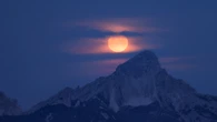 La Luna sfiora le Dolomiti in un incontro tra cielo e montagna