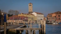 Ragazzi giocano a palla in campo veneziano, genitori in caserma