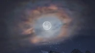 Un'aureola di nuvole per la Luna sopra le cime delle Dolomiti