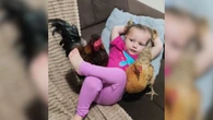 Menina de 2 anos curte ar condicionado no sofá com galinha e galo