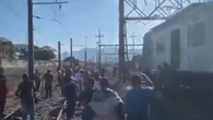Passageiros caminham pelos trilhos do trem após incêndio no Rio