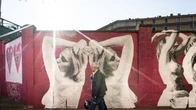 Un muro fucsia ricoperto di corpi di donne che danzano: la street art per la ricerca sul tumore al seno