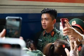 Thượng úy Lê Hoàng Hiệp được các chiến sĩ khác “hộ tống” di chuyển ra khỏi vòng vây của đông đảo người dân tại ga Hà Nội