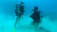 Diver drops to one knee 100 feet underwater in breathtaking Fiji shipwreck proposal