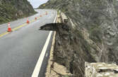 Crews escort cars around damaged portion of a California highway