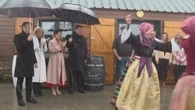 Xi e Macron assistono a una anza folkloristica sotto il diluvio