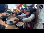 Palestinos desplazados en Jan Yunis hacen cola para recibir comida