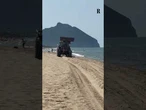Una ruspa fa lo slalom tra i bagnanti sulla spiaggia di Sabaudia