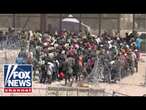 WATCH: Hundreds of migrants breach razor and rush the US border