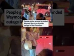 People gather around Waymos after power outage