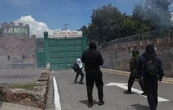 Padres de los 43 bloquean autopista del Sol; normalistas lanzan petardos a cuartel militar