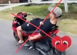 Không đội mũ bảo hiểm, buông cả 2 tay nằm dài trên yên khi lái xe máy trên đường