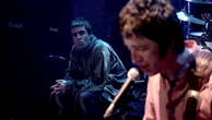 Liam Gallagher appears to look furiously at Noel during 2009 Oasis gig