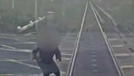 Watch: Woman comes 'within half a second of being hit by train‘