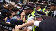 Police scuffle with protesters outside hotel housing immigrants