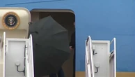 Trump struggles to take down umbrella during storm