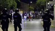 Anti-migrant groups throw bottles at riot police in Spain