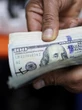 Dólar inicia o mês em queda e volta a ser negociado abaixo de R$ 5,70