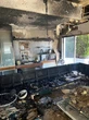 Buurman gryp sy tuinslang en help brand in Groenpunt-huis blus