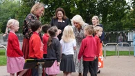 Queen bundles into phone box with schoolchildren as she visits gallery