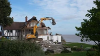 Demolition of clifftop home threatened by coastal erosion gets under way
