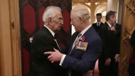 King hugs Second World War veteran, 105, at Windsor remembrance reception