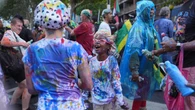 Carnival revellers squirt paint as part of colourful Caribbean celebration