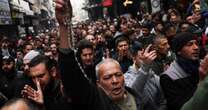 Hundreds protest in Damascus after hooded figures set Christmas tree ablaze