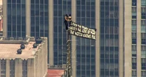 Two trespassers climb to top of Empire State Building, fly banner