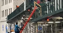 Knicks fans climb up scaffolding to get a better view of parade