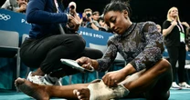 Biles battles through calf pain to push U.S. into the lead