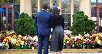 Vances lay flowers at Annunciation Catholic Church memorial