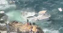 Terrifying moment yacht full of tourists smashes into rocks and sinks on New Year's Day