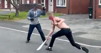 Bloodied men slash each other with machetes in street as woman begs them to stop