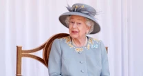 Touching gesture behind the Queen's aquamarine Trooping the Colour brooch
